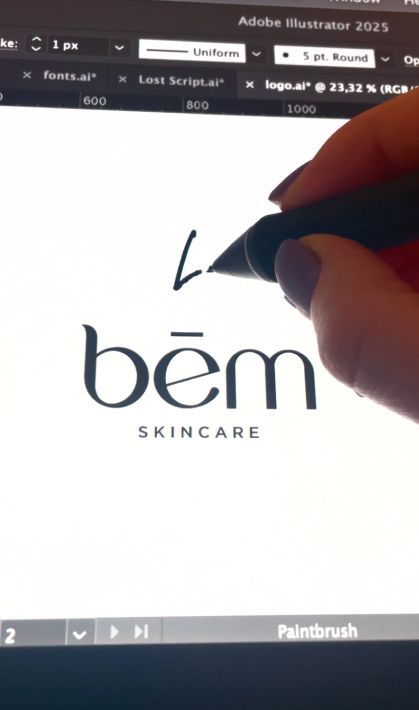 Hand drawing a “bém skincare” wordmark logo on a tablet, showing the logo design process for a cosmetics brand step 2