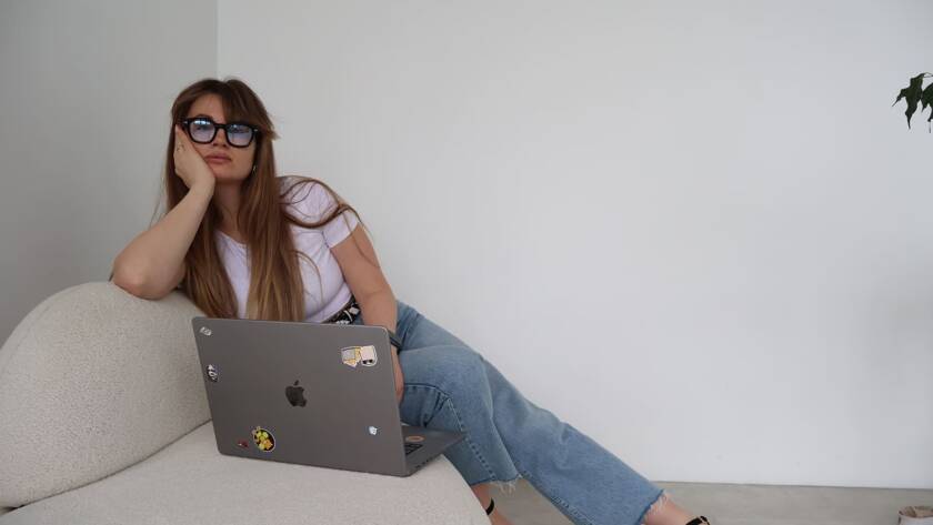 Personal branding photo featuring a designer working on a laptop in a minimalist home studio, illustrating the story of becoming a designer and building a creative career.